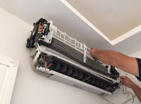 清掃のために解体中のエアコン